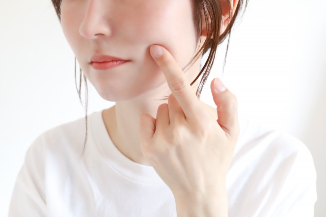 女性が頬に指を当てる
